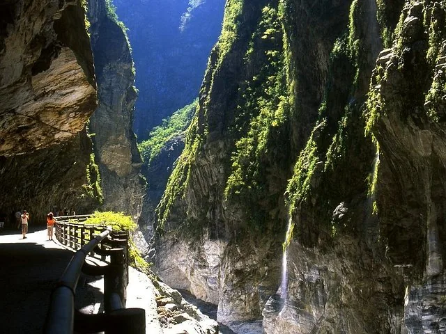 Lush green mountains rising steeply from the deep blue ocean coastline.