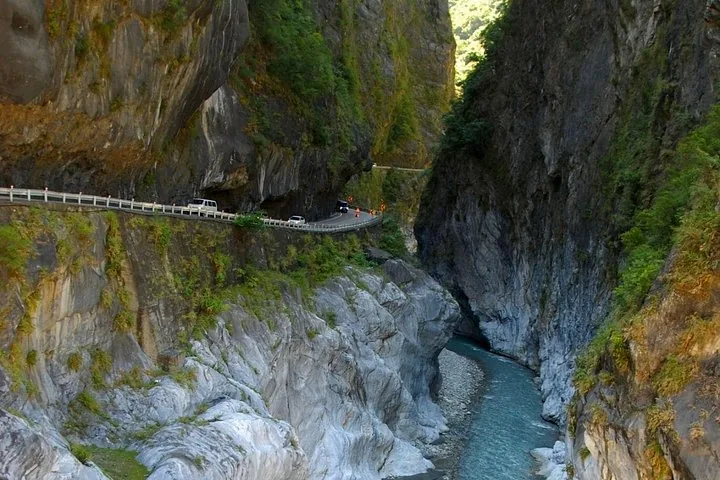 A winding road carved into the steep cliffs of a narrow river gorge.