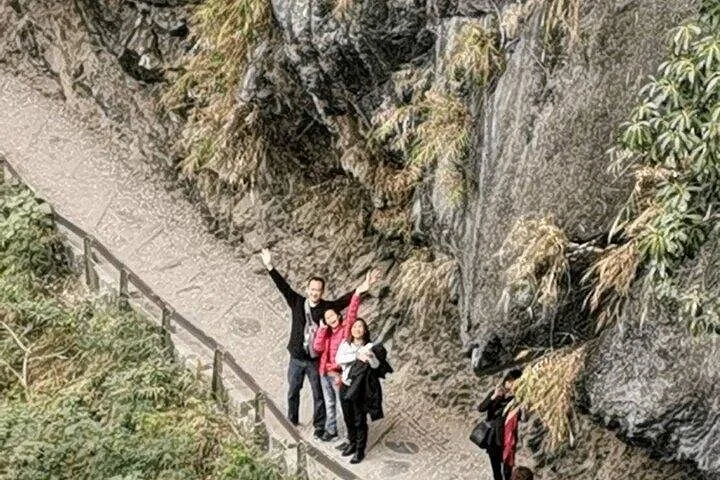 A road winding tightly around a massive rocky cliff face in Taroko Gorge.